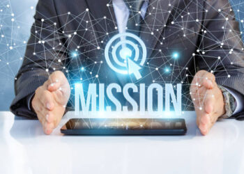 Businessman shows the word mission on the virtual screen.
